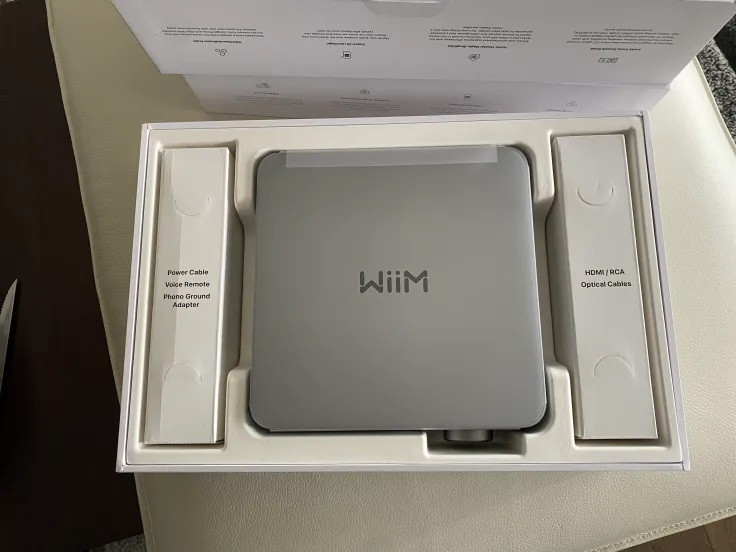 inside the box — the Amp, quick-start guide, remote, and the power, HDMI/RCA/optical cables and phono ground adapter in their labelled compartments