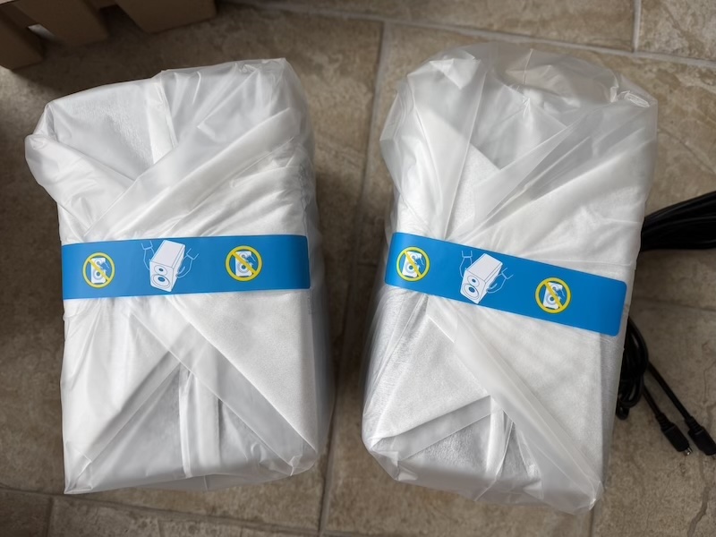 both M90 speakers still in protective covers on the floor