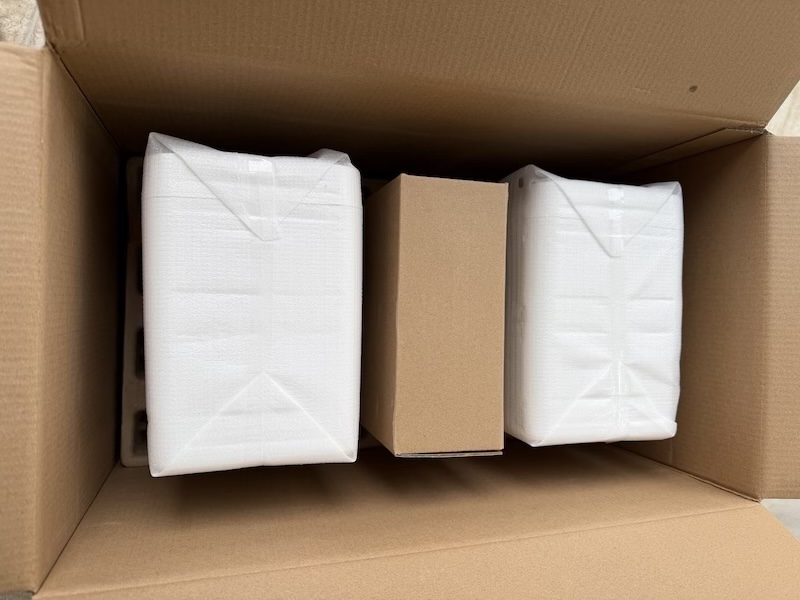 speakers packed below the accessory layer in protective plastic