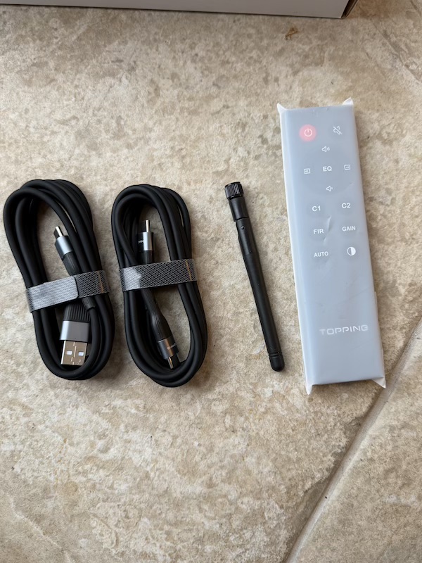 accessories laid out showing cables, bluetooth antenna, and remote