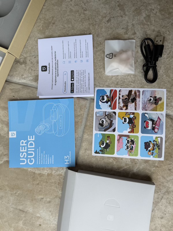 accessories box contents — eartip bag, cable, manual, stickers