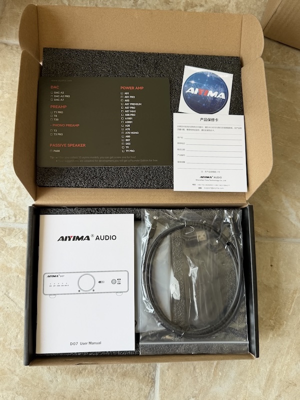 the box open, showing the manual, warranty card and USB cable