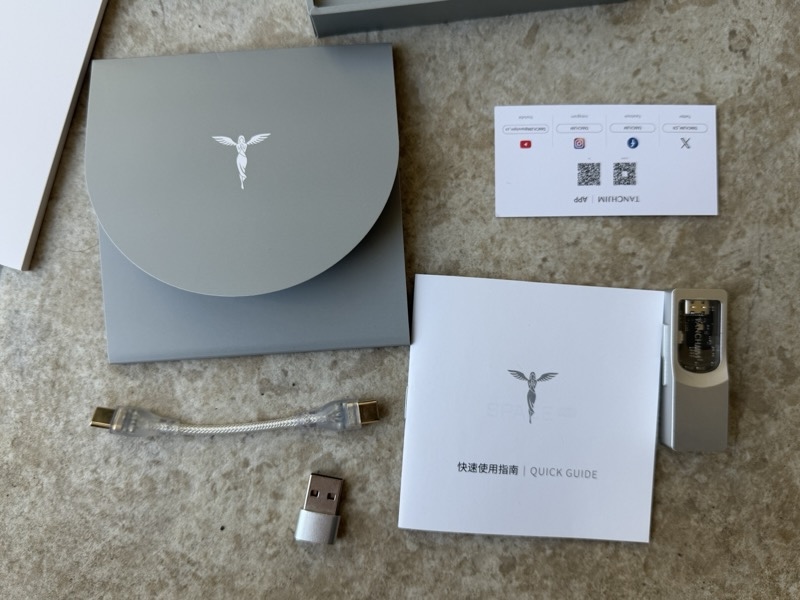 box contents: unit, cable, adapter, quick guide, and app card