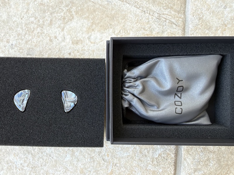 cozoy iems with drawstring bag underneath in the box