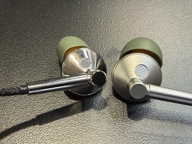 the pair of earpieces laid flat, showing the green silicone eartips