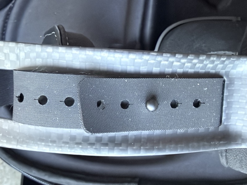 the headband adjustment strap, showing the punched-hole sizing mechanism