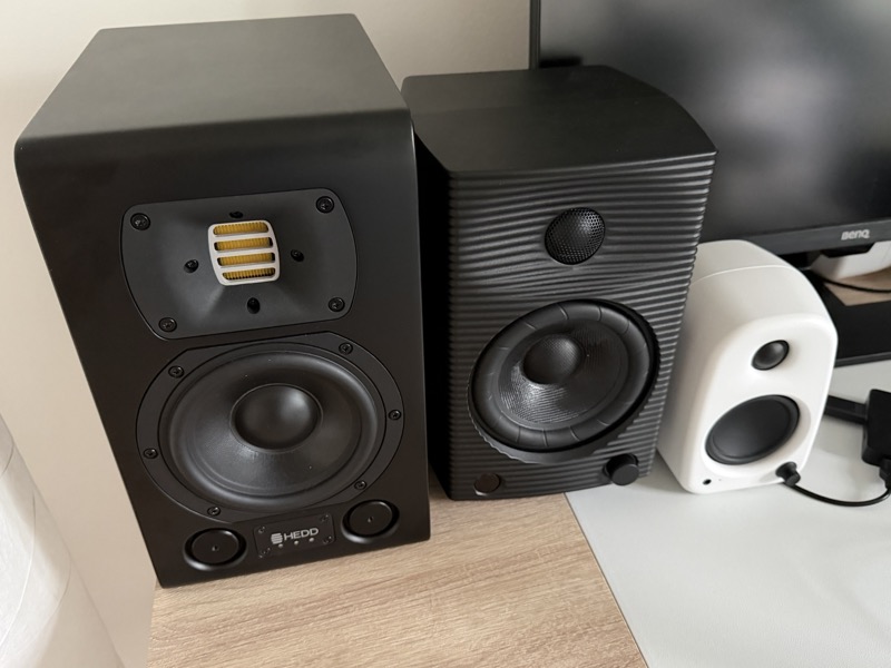 the HEDD Type 05 MK2 beside another monitor speaker and a small white desktop speaker for scale