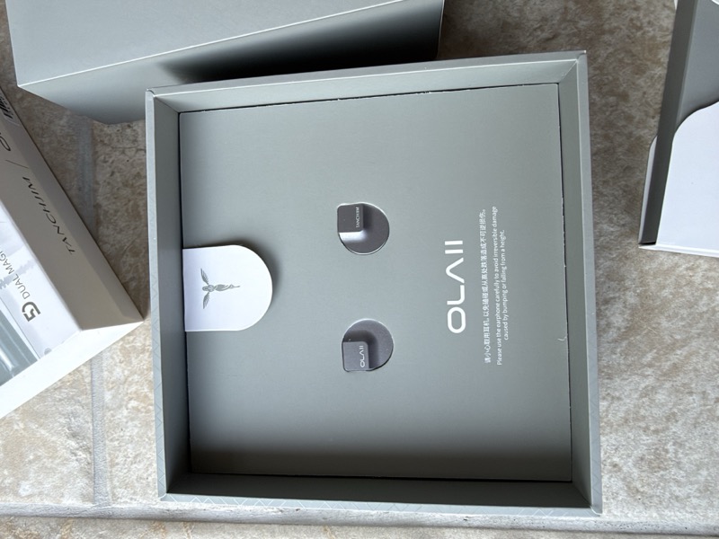 open tray with both earpieces and the pull-tab card