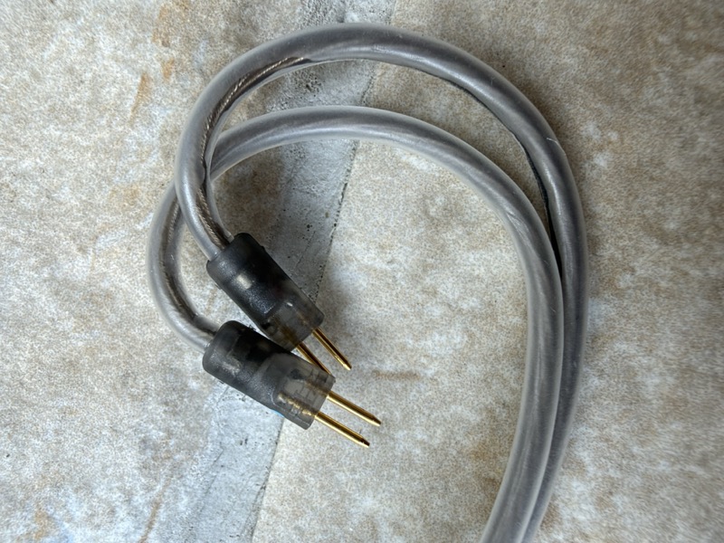 the cable coiled, showing the twisted-pair construction and 2-pin connectors
