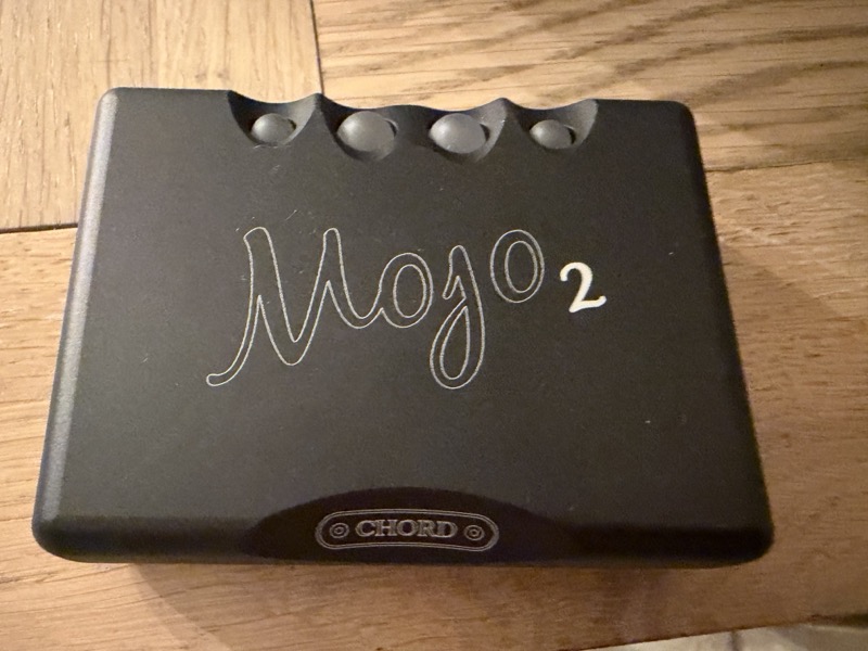 chord mojo 2 sitting on a wood desk, top face up with its four control spheres visible