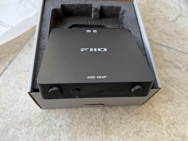 the air amp unboxed in its foam tray, front panel facing up