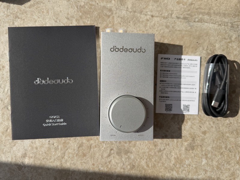 the box contents laid out — the amplifier, a black quick start guide, a FiiO warranty card and a USB-C cable