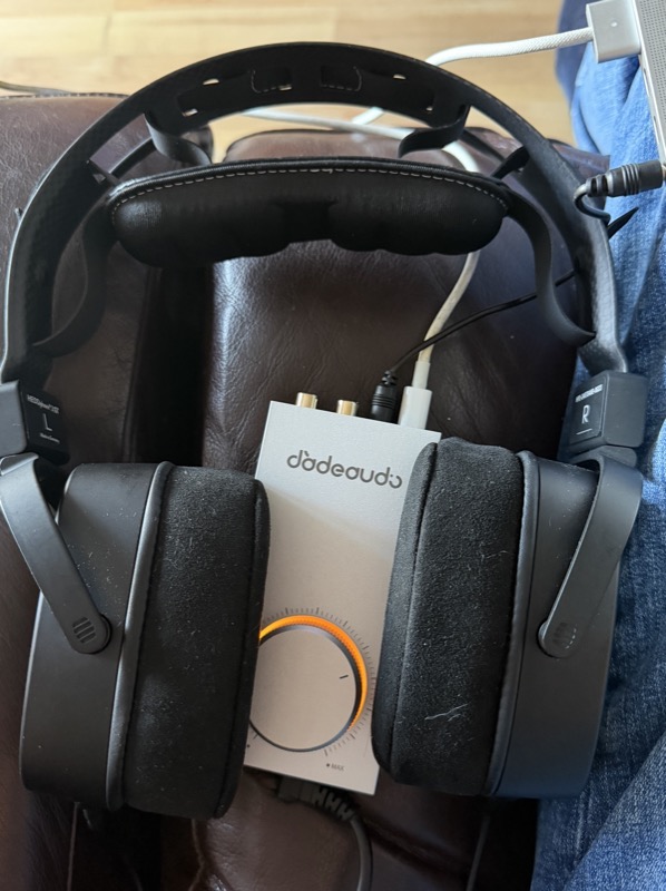 the Gigas1 rear panel connected via RCA and 3.5mm with headphones resting beside it on an armchair