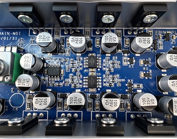 close-up of the Gigas1 circuit board showing the power transistors clamped to the chassis and the electrolytic capacitors around them