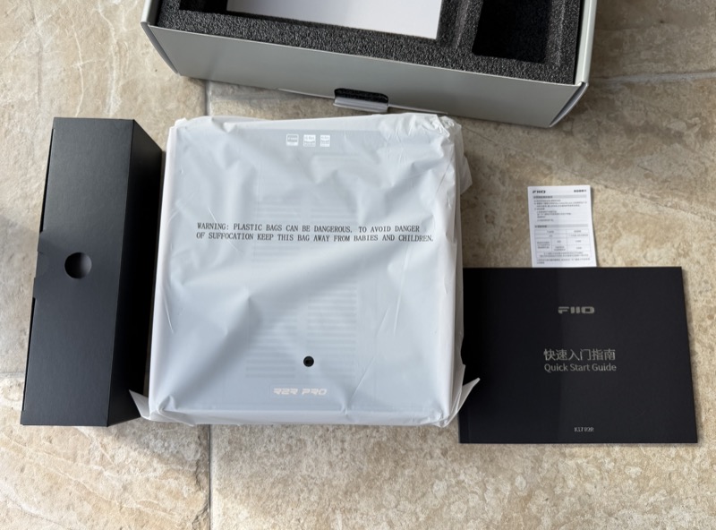 the wrapped unit laid out with the quick start guide and warranty card
