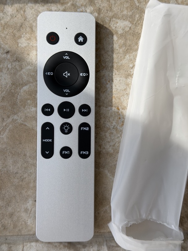 front of the aluminium remote with volume and eq ring, transport keys, mode rocker and three fn buttons