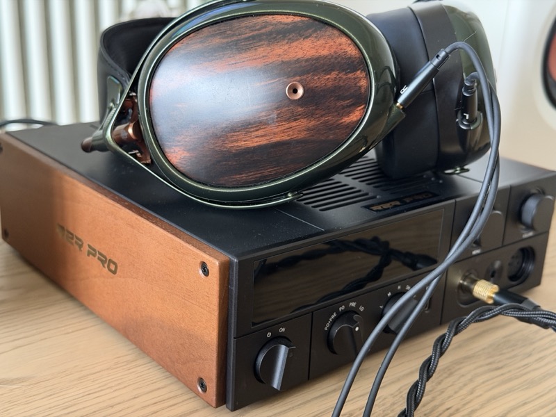 the meze strada, with its ebony earcups, resting on top of the fiio k17 r2r and plugged into its 4.4 mm balanced output