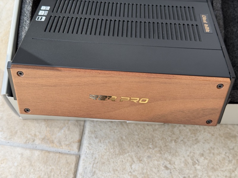 angled view of the walnut side cheek showing its thickness against the black chassis