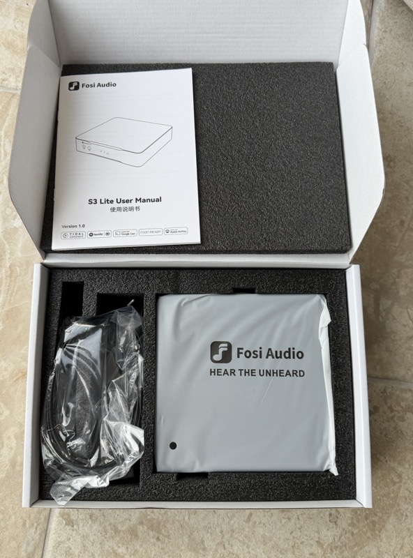 the opened box showing the s3 lite user manual above the foam-packed unit