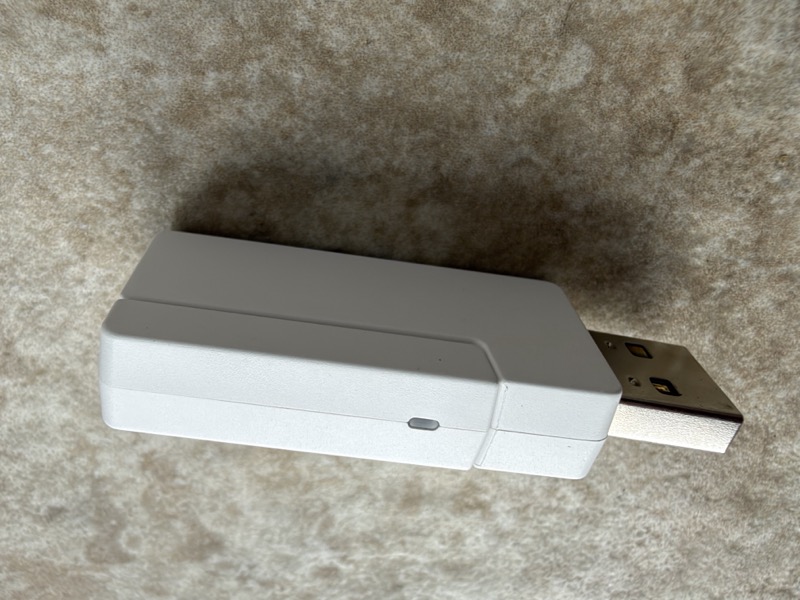 the white 2.4ghz usb-a dongle with its cap slid back