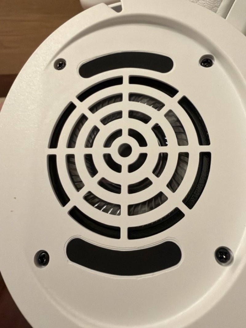 the earpad removed showing the white baffle plate with its concentric grille, four screws and two damping slots