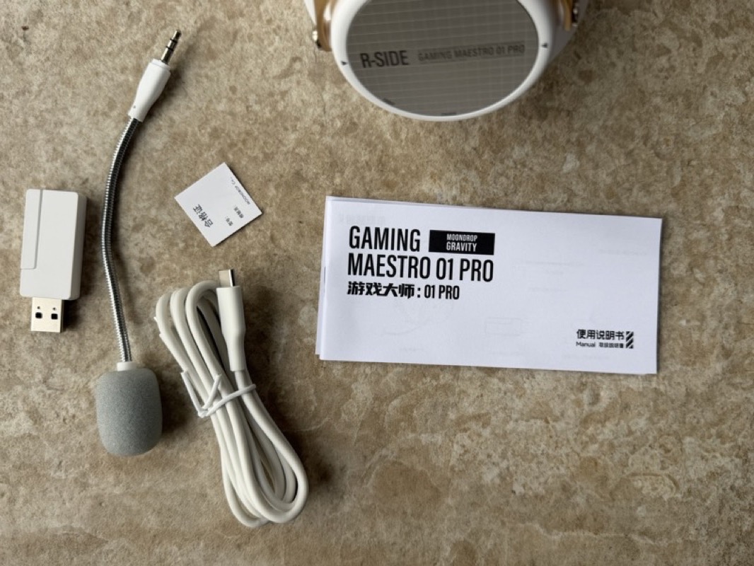 the gm01 pro accessories laid out — the 2.4ghz usb dongle, the detachable boom microphone, a usb-c cable and the manual