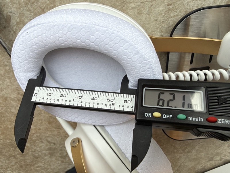 a digital caliper measuring the long axis of the stock earpad opening at 62.1 mm