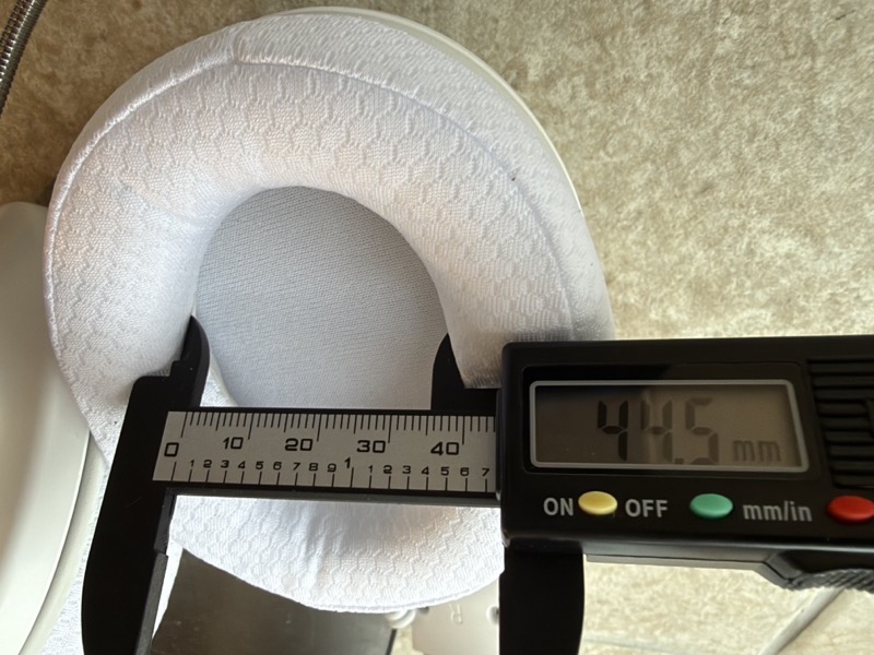 a digital caliper measuring the short axis of the stock earpad opening at 44.5 mm