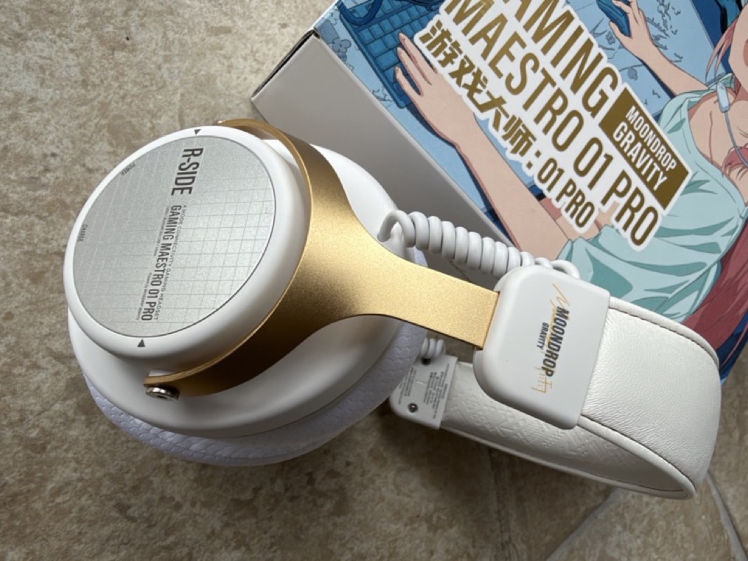 the headphone lying on its side showing the r-side cup plate and gold yoke